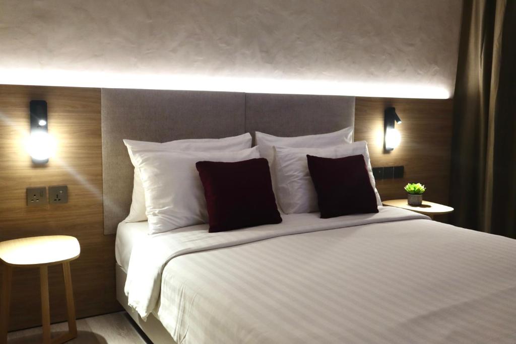 a bedroom with a large white bed with two pillows at The Brunei Hotel in Bandar Seri Begawan