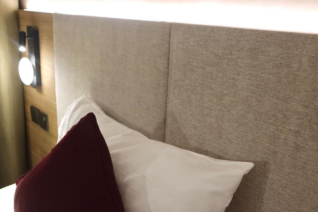a headboard of a bed with a red and white pillow at The Brunei Hotel in Bandar Seri Begawan