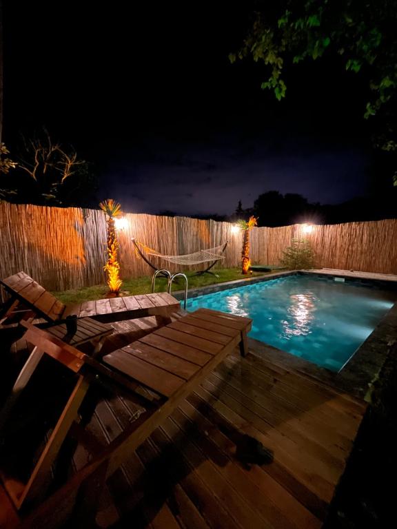 uma piscina no quintal à noite com uma rede de descanso e uma cerca em SapancaAdabungalov em Sapanca