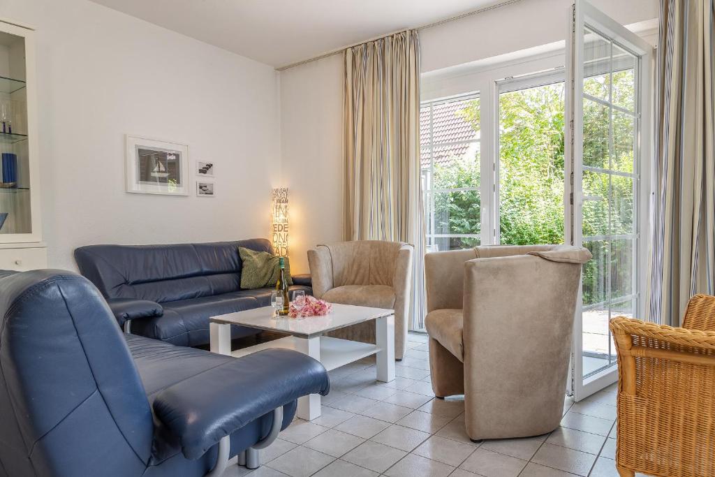 a living room with a couch and chairs and a table at Ferienhaus 50009 in Carolinensiel