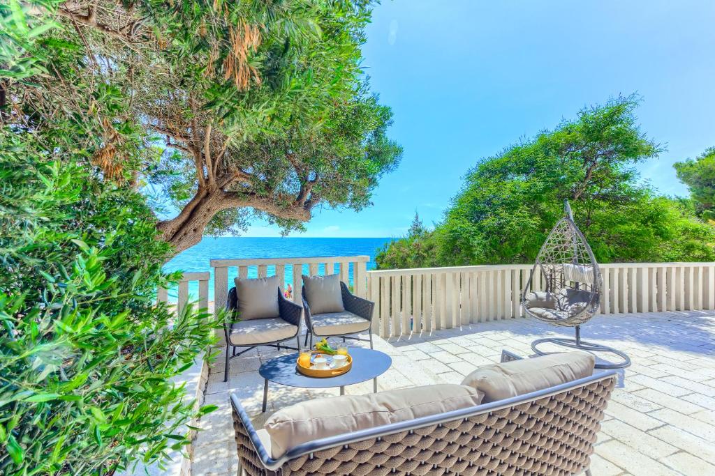 a patio with a couch and chairs and a table at Luxury beach in Ivan Dolac