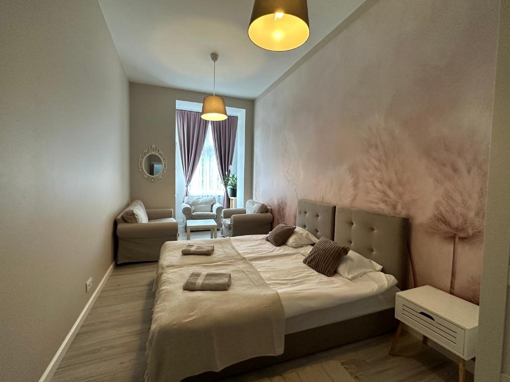 a bedroom with a large bed and a living room at Apartament Wroclawia in Wrocław