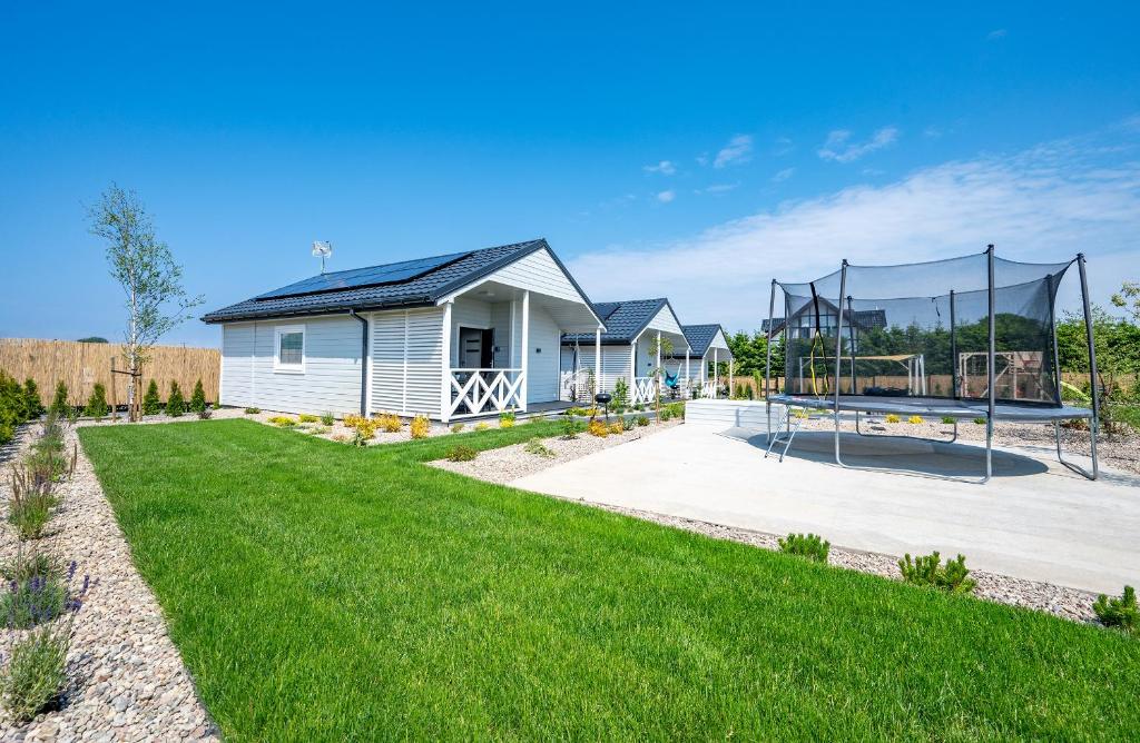 a house with a playground in the yard at Domki Hulaj Dusza in Bobolin