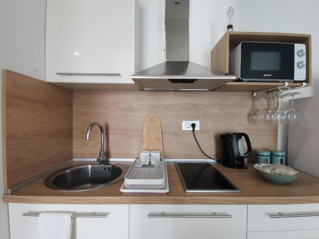 a kitchen counter with a sink and a microwave at Beach Pearl in Bečići