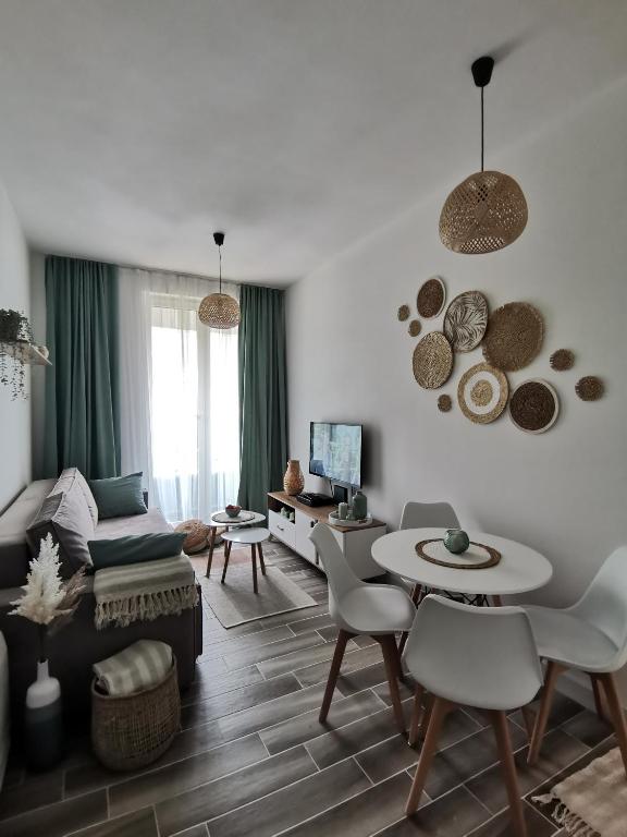 a living room with a couch and a table and chairs at Beach Pearl in Bečići