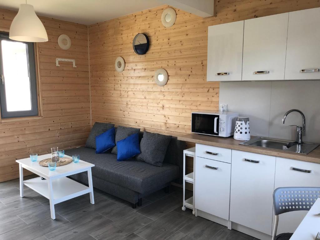 ein kleines Wohnzimmer mit einem Sofa und einem Tisch in der Unterkunft Domki Wypoczynkowe "Sea Breeze" in Rewal