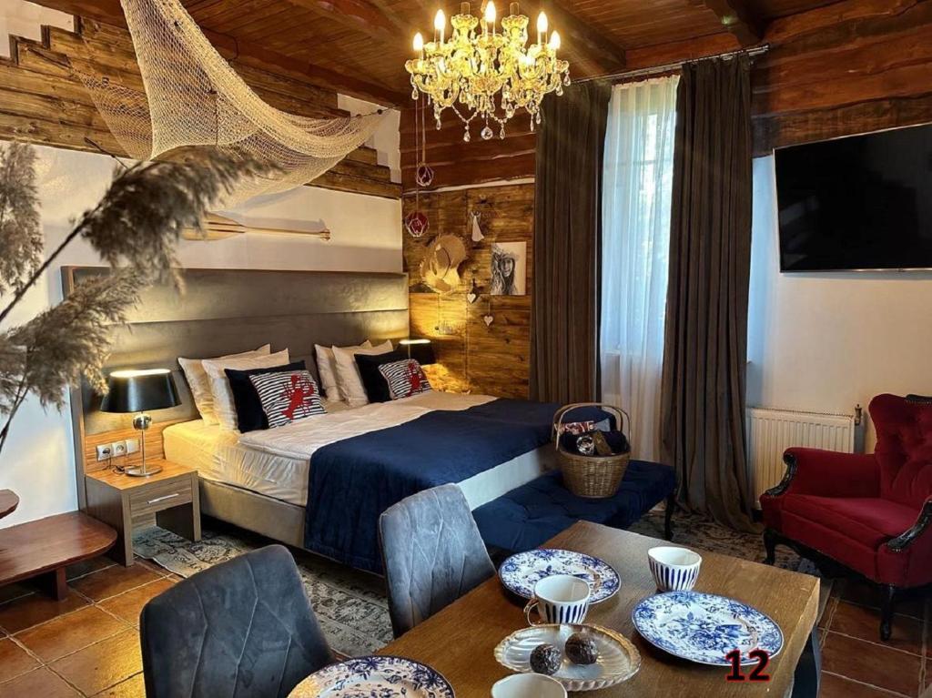 1 dormitorio con cama y lámpara de araña en Willa Detlafówka en Dębki