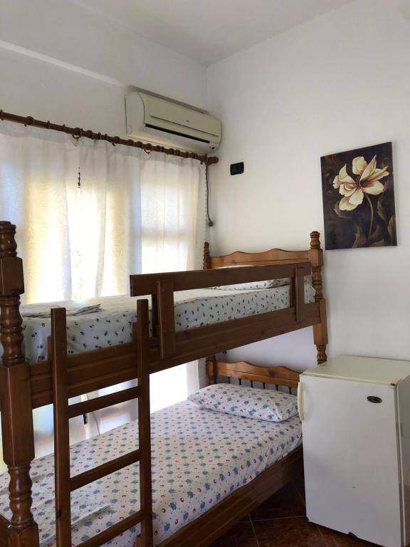 a bedroom with two bunk beds and a refrigerator at Villa Edi in Vlorë