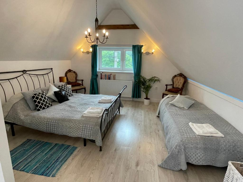 1 dormitorio con 2 camas y ventana en Rose Cottage en Prievidza