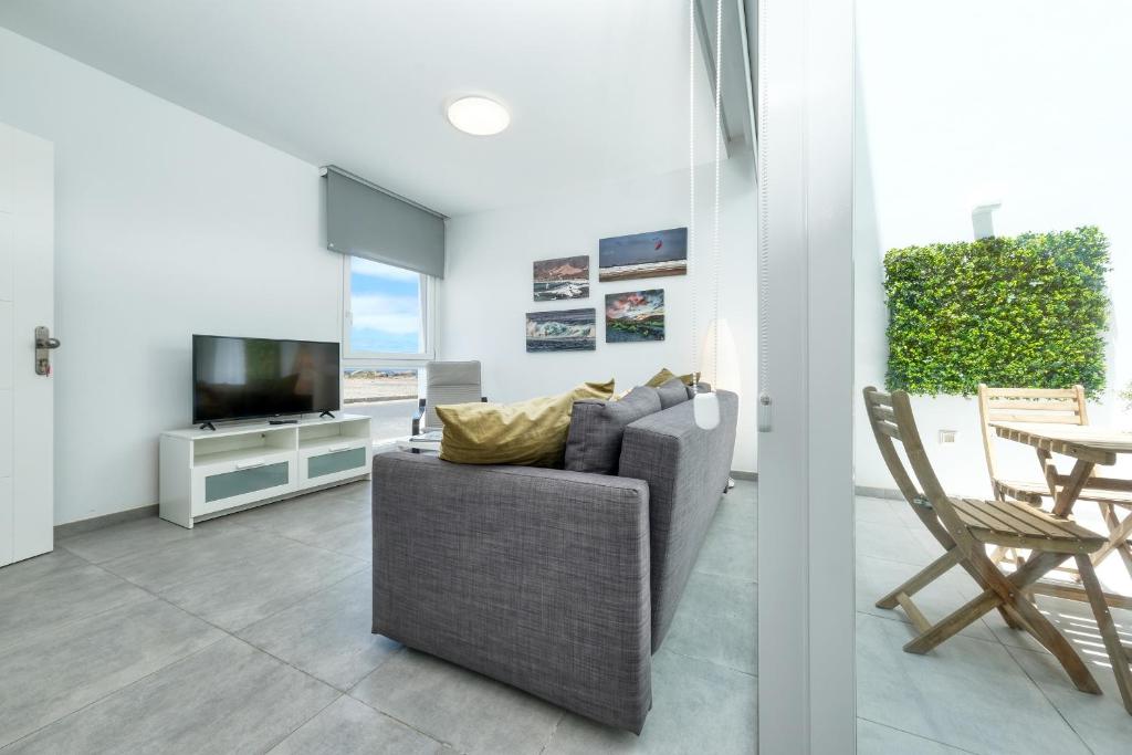 a living room with a couch and a television at Karma Famara 2 25m del mar in Famara