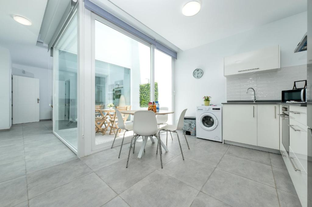a kitchen and dining room with a table and chairs at Karma Famara 2 25m del mar in Famara