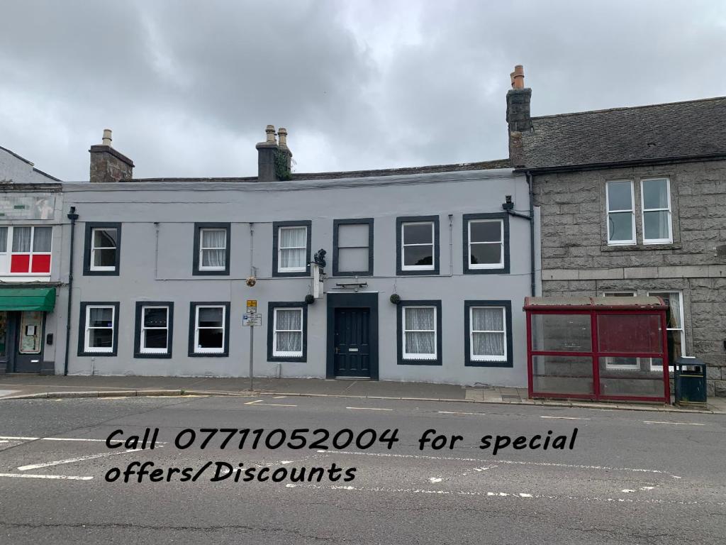 a white building on the corner of a street at The Maxwell Arms Hotel in Dalbeattie