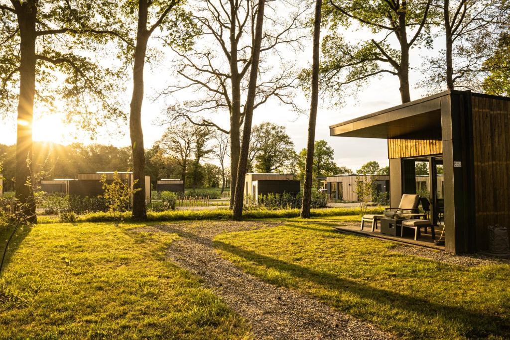 a small house in the middle of a field with trees at Hofparken Wiltershaar in Kotten