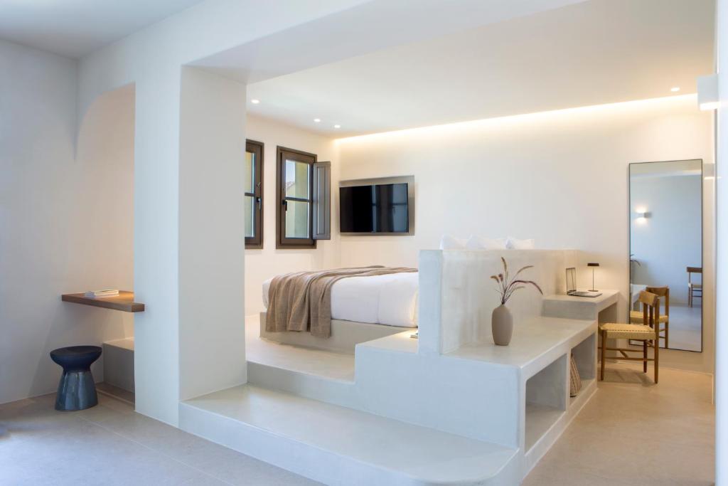 una camera bianca con letto e specchio di Elessa Hotel a Pyrgos