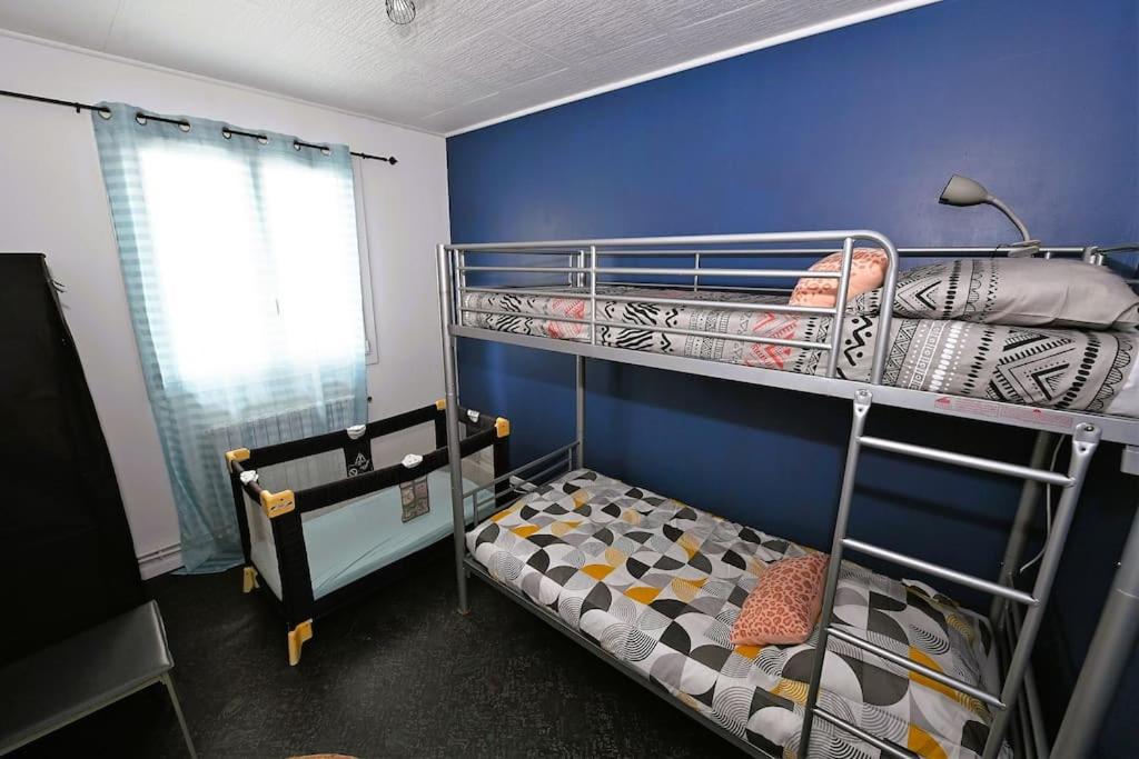 1 dormitorio con 2 literas y pared azul en Les Cimes, en Bagnères-de-Bigorre