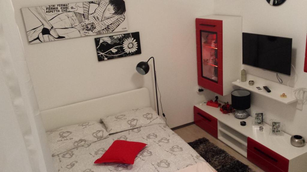 a small bedroom with a bed and a red mirror at Studio Apartment Kala in Split