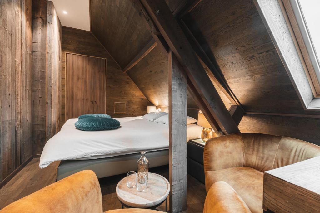 Schlafzimmer im Dachgeschoss mit einem Bett und 2 Stühlen in der Unterkunft De Goedendag in Brügge