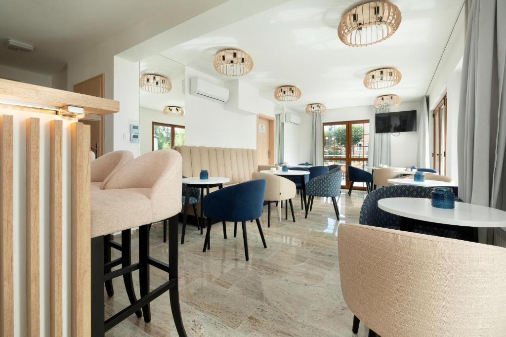 restauracja ze stołami, krzesłami i oknami w obiekcie Willa Florek w Rewalu