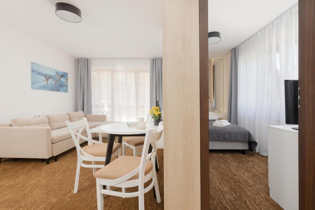 salon ze stołem i krzesłami oraz salon w obiekcie Willa Florek w Rewalu