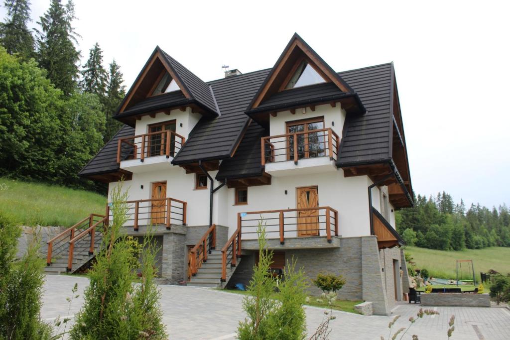 a large house with a gambrel roof at Babcia Góralka house in Bukowina Tatrzańska