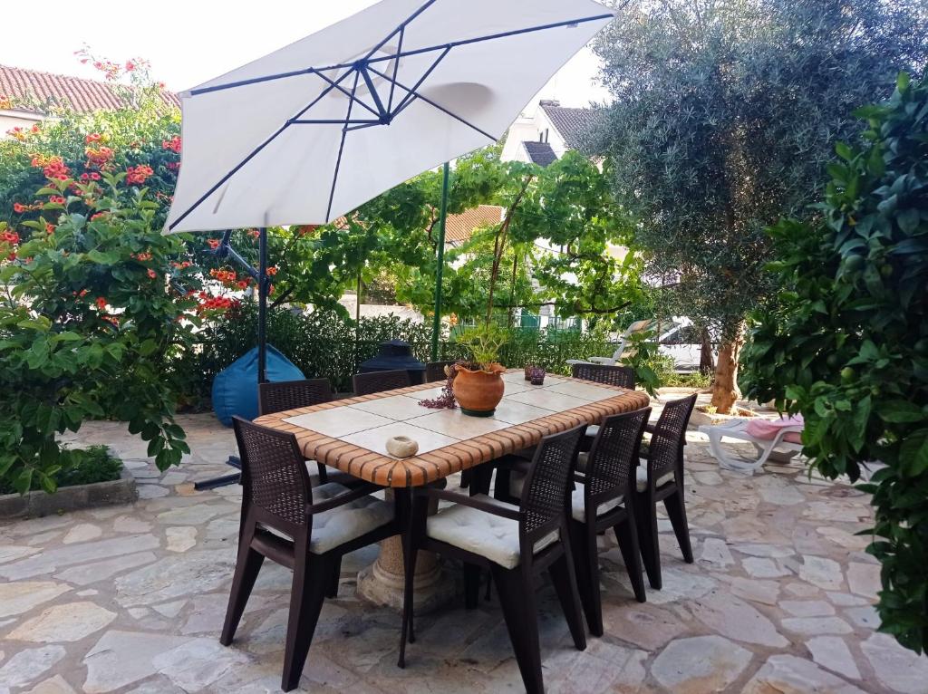 una mesa con sillas y una sombrilla en el patio en Alojamento local Os Maias, en Mirandela