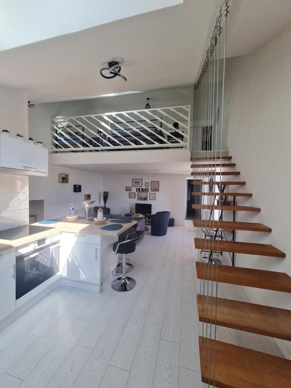 um quarto com uma escada e uma cozinha com uma secretária em Le Bastion em Rocroi