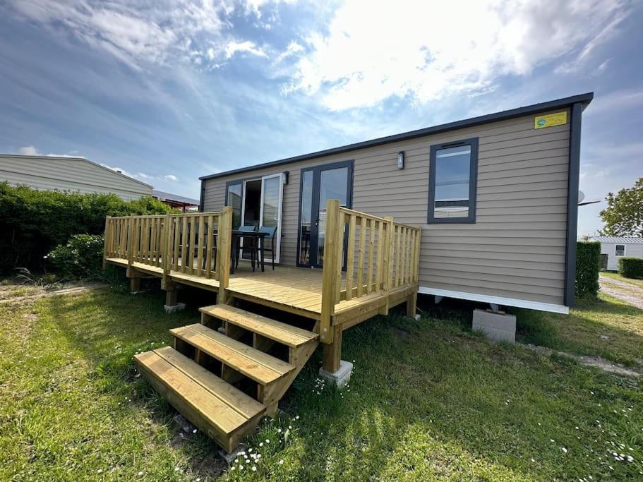 a tiny house with a deck and a table at O'hara mobil-home haut de gamme à 300m de la plage in Ambleteuse