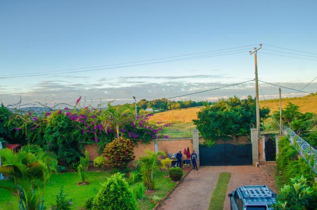 a group of people walking in a garden at Room in Villa - The romantic atmosphere of the red room to discover the pleasure of a stay in Antananarivo