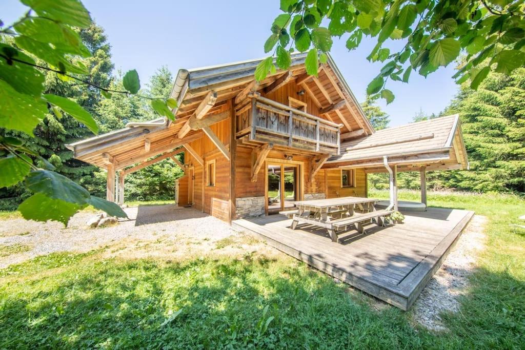 une cabane en rondins avec une table de pique-nique et une terrasse dans l'établissement Chalet Cafourotte, au calme, SPA, à Gérardmer