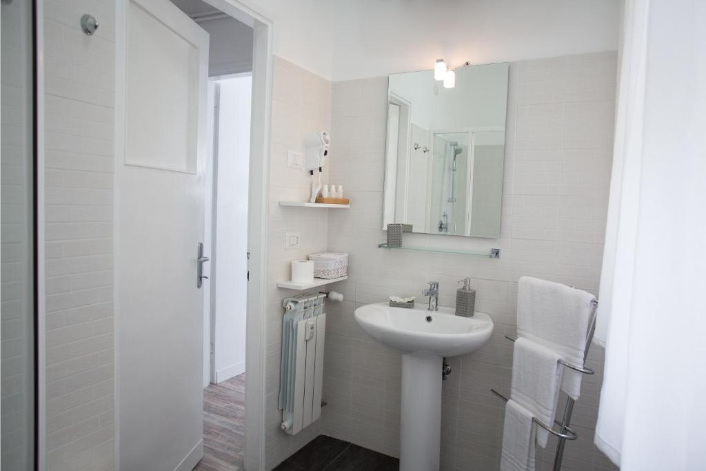 bagno bianco con lavandino e specchio di St Peter Lodge a Roma