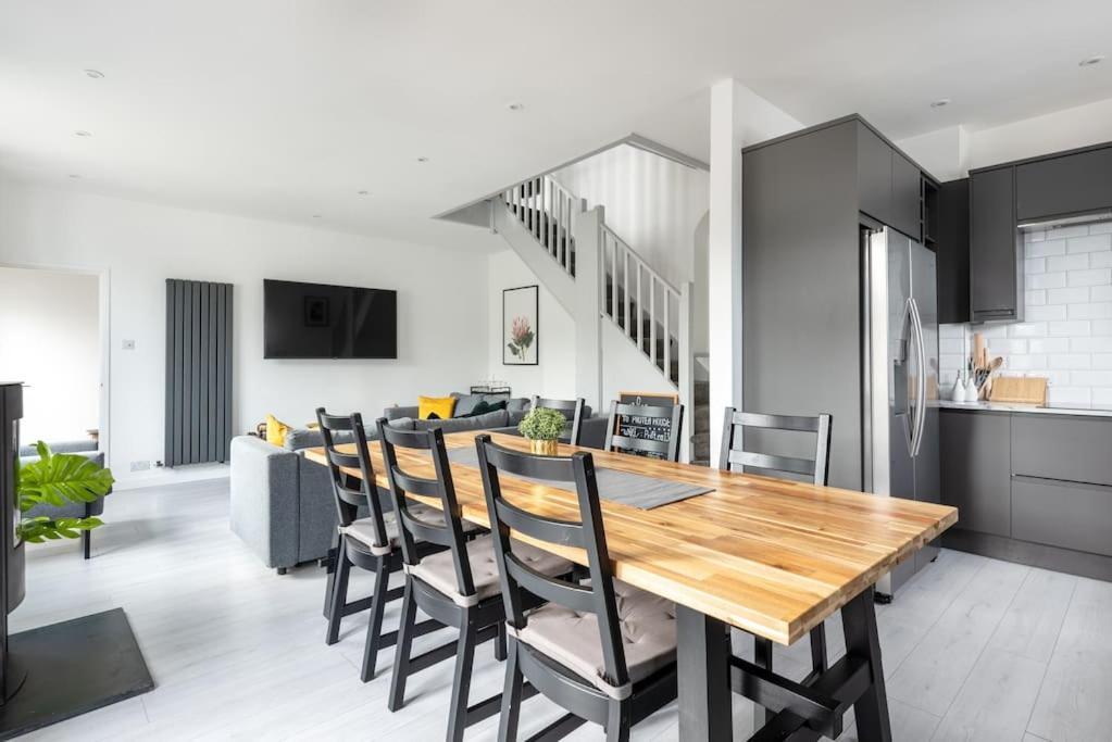 uma cozinha e sala de jantar com uma mesa de madeira e cadeiras em Spacious, Modern Home, Central Newquay w/ parking em Newquay
