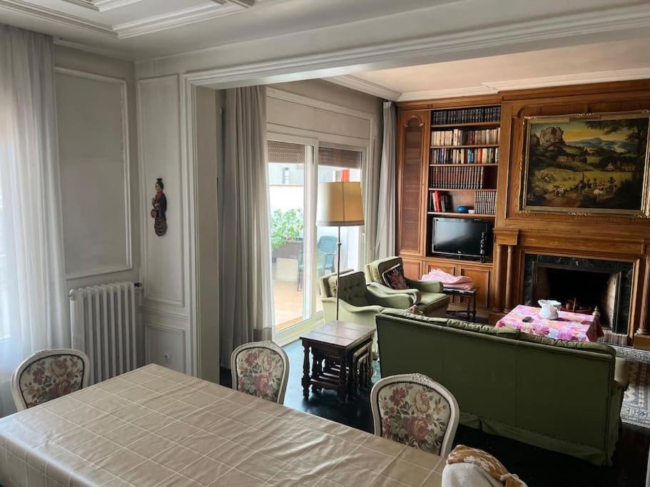 - un salon avec une table et une cheminée dans l'établissement Gran piso Terrassa centro rambla 5 habitaciones, à Terrassa