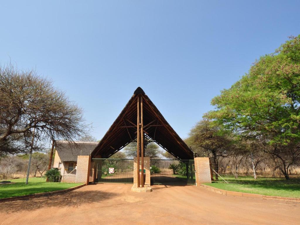 una grande struttura in legno di fronte a un edificio di Mokuru Private Nature Reserve a Brits