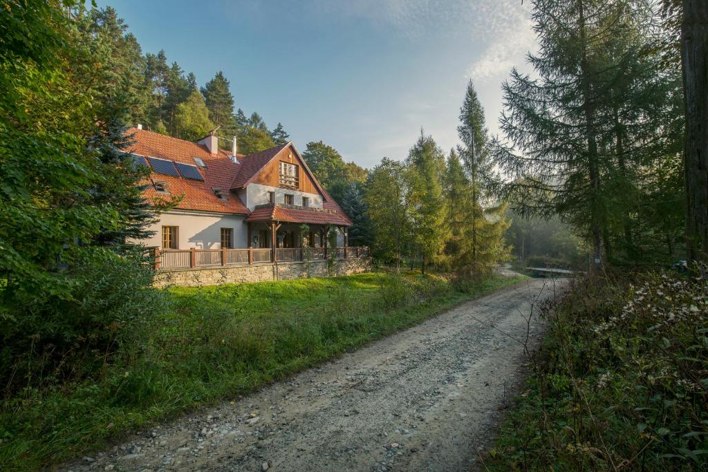 une maison sur le côté d'un chemin de terre dans l'établissement Biały Dom W ROPKI, à Ropki