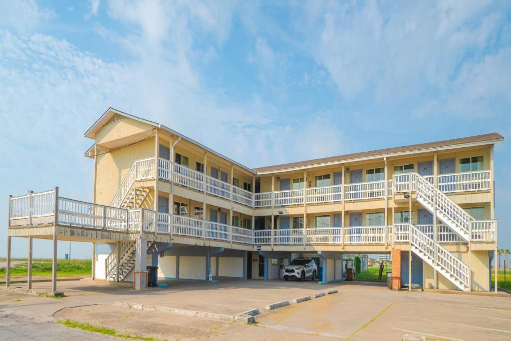 a large building with two balconies and a parking lot at Budget Inn By OYO Corpus Christi Beach in Corpus Christi