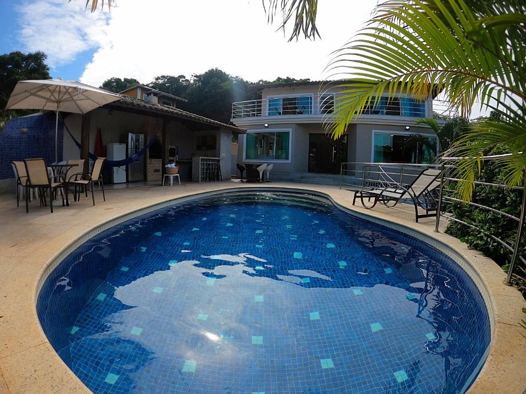 una gran piscina azul frente a una casa en Hospedagem do Gaúcho, en Búzios