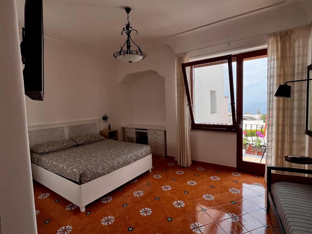 a bedroom with a bed and a large window at Casa Dora in Anacapri