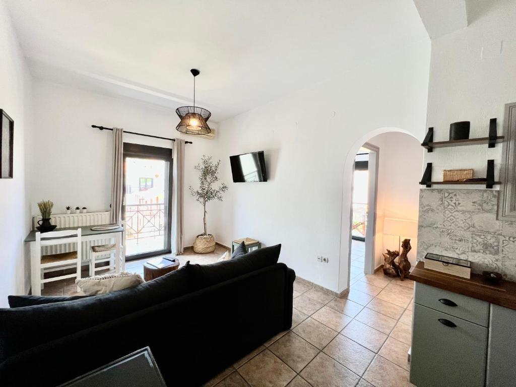 a living room with a couch and a tv at Rania Residence in Skopelos Town
