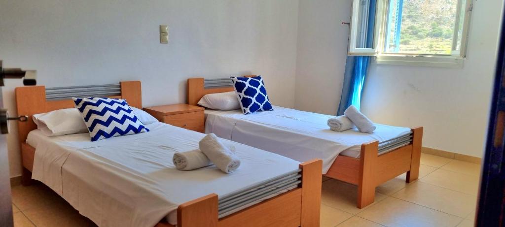 a room with two beds and a window at Zafeiris Apartments in Livadia