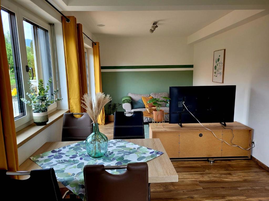 sala de estar con mesa y TV en Ferienwohnung Am Hochfeld, en Bad Kohlgrub