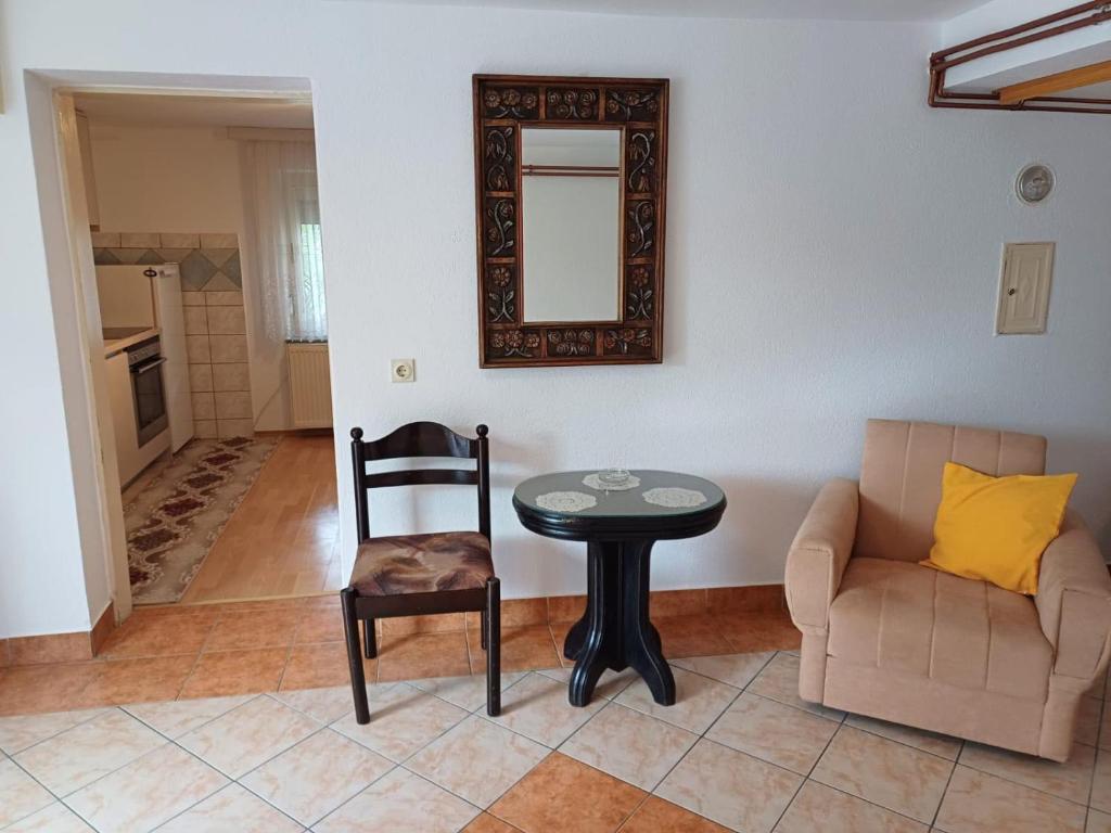 - un salon avec une table, un canapé et un miroir dans l'établissement Apartman DIJANA BANJA LUKA, à Banja Luka