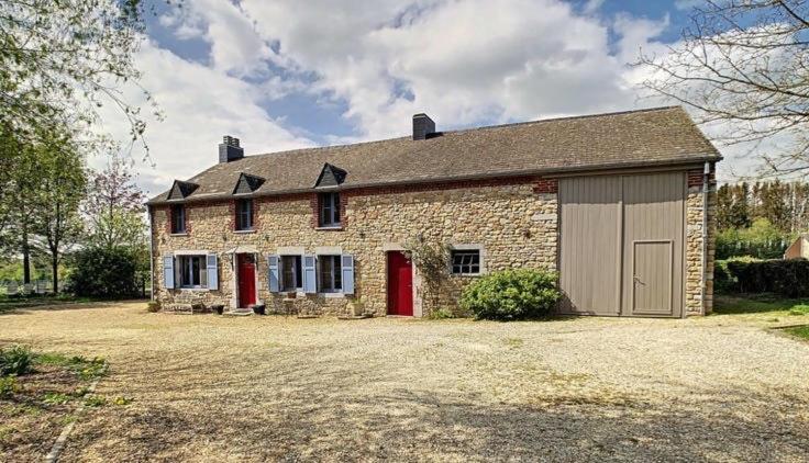 a stone house with red doors and a garage at Habitat in Momignies