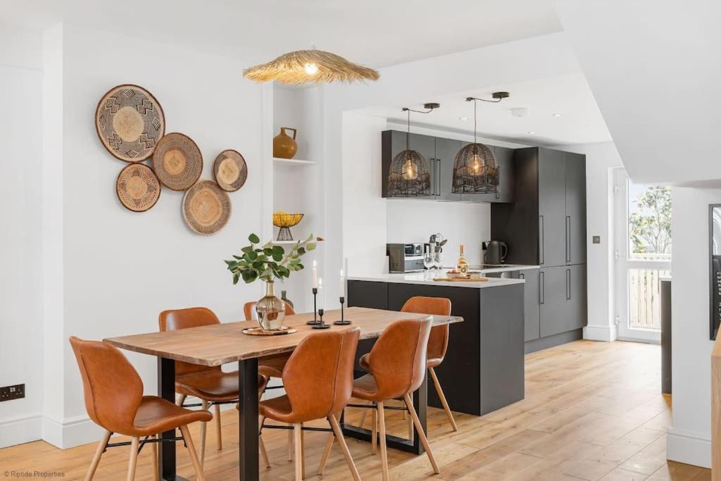 uma cozinha e sala de jantar com mesa e cadeiras em Stylish & Modern Home, Central Newquay w/parking em Newquay