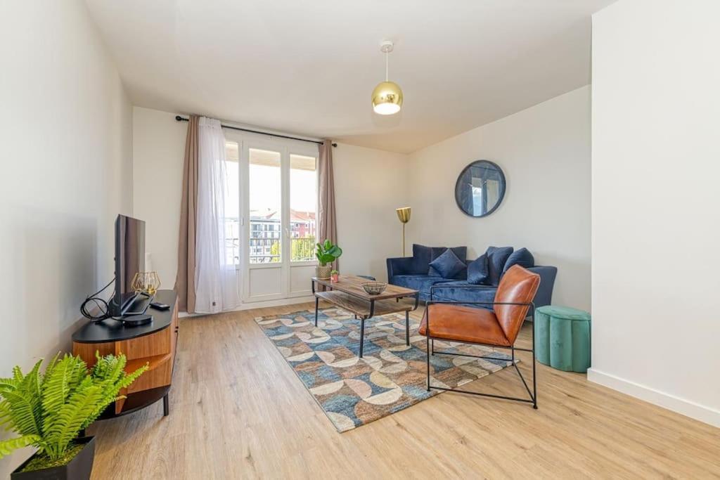 un salon avec un canapé bleu et une table dans l'établissement Haut standing, 4 ch dont 2 sdb privé, clim, fibre, à Grenoble