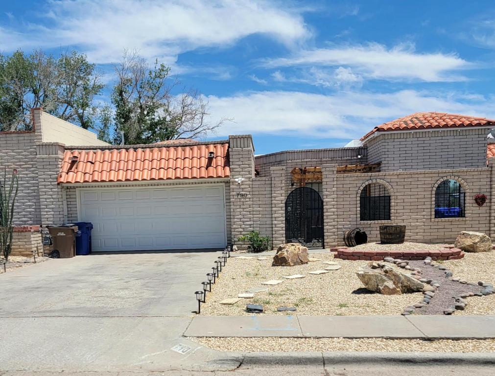 ein großes Backsteinhaus mit Garage in der Unterkunft The Ritz Spa Sanctuary hot tub/patio/fam/pet in Las Cruces