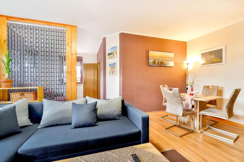 Ferienwohnungen Bernstein في شترالزوند: غرفة معيشة مع أريكة زرقاء وطاولة