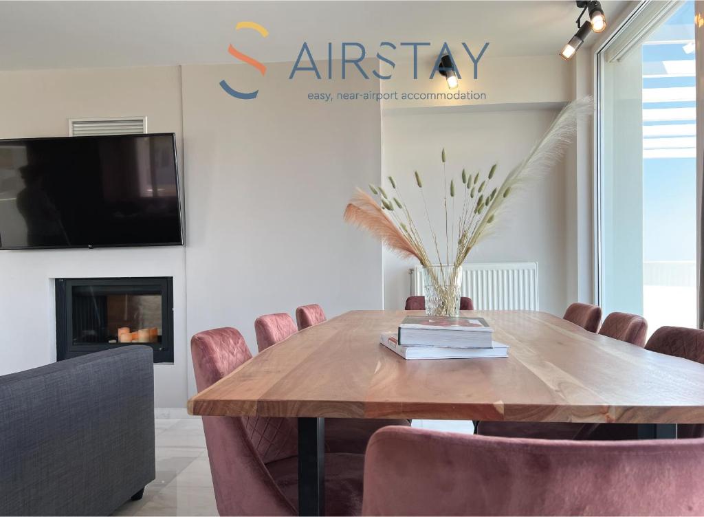 - une salle à manger avec une table et des chaises en bois dans l'établissement Akali Apartment airport by Airstay, à Spáta