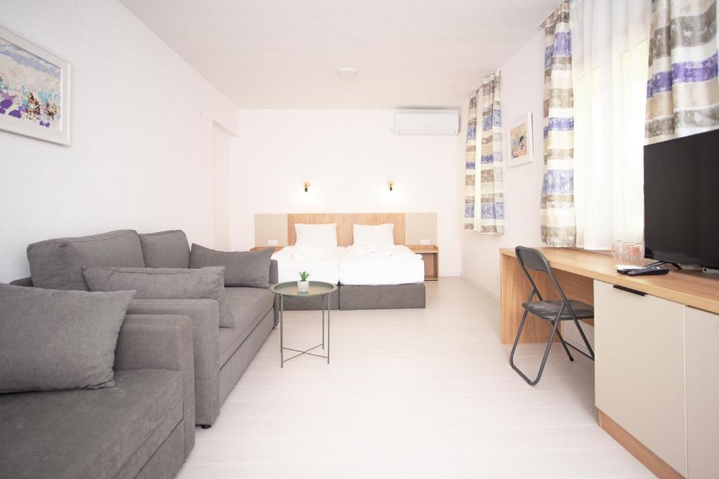 ein Wohnzimmer mit einem Sofa und einem Bett in der Unterkunft NACIONAL in Trebinje