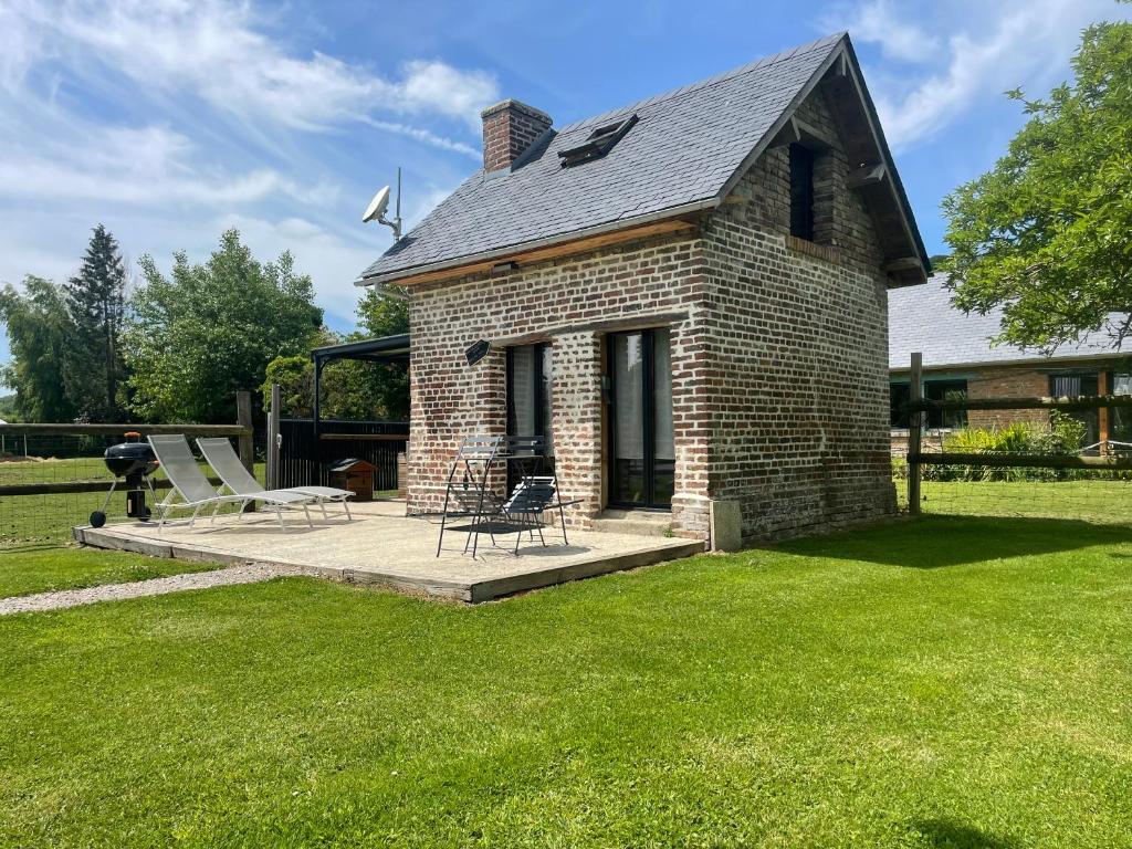une maison en briques avec une terrasse dans une cour dans l'établissement La maison du bonheur "Le petit Four", à Saint-Ouen-sous-Bailly