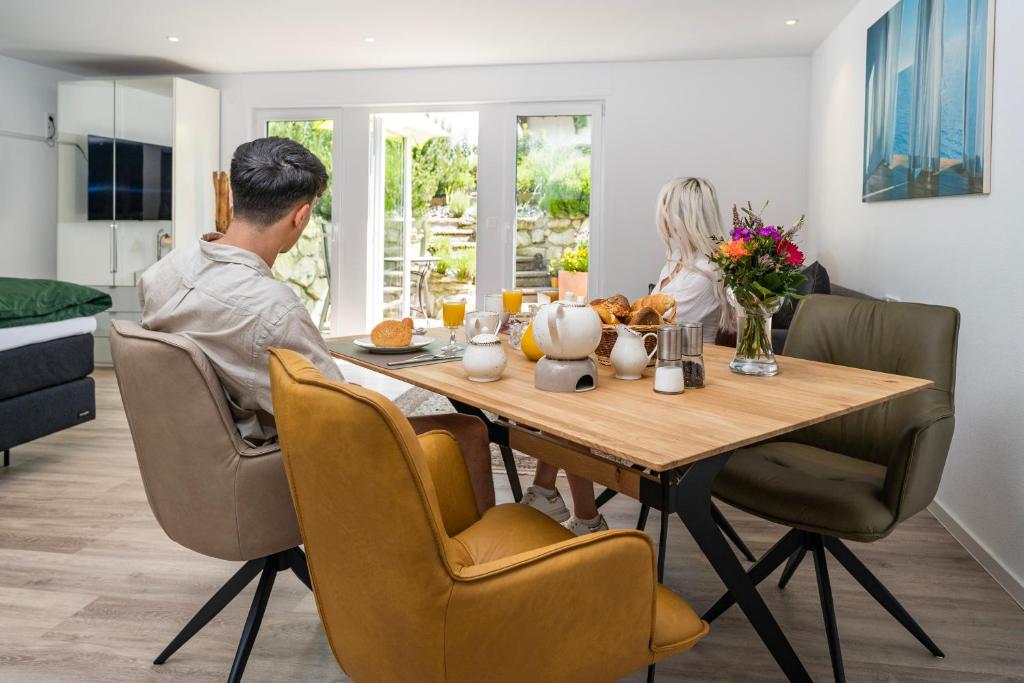 un homme et une femme assis à une table de salle à manger dans l'établissement Haus Anni, à Immenstaad am Bodensee